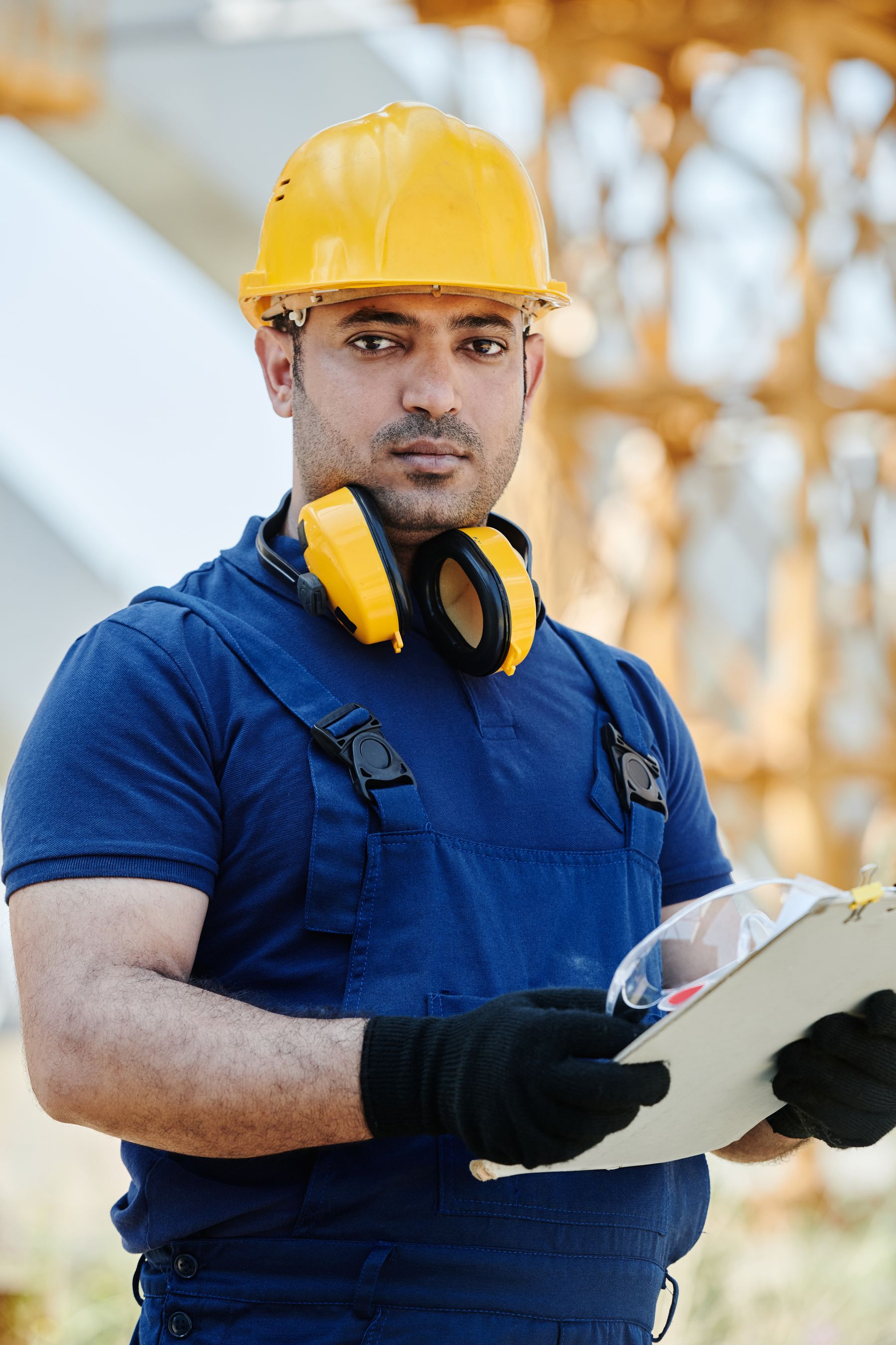 Profesional con uniforme azul, casco amarillo y elementos de protección